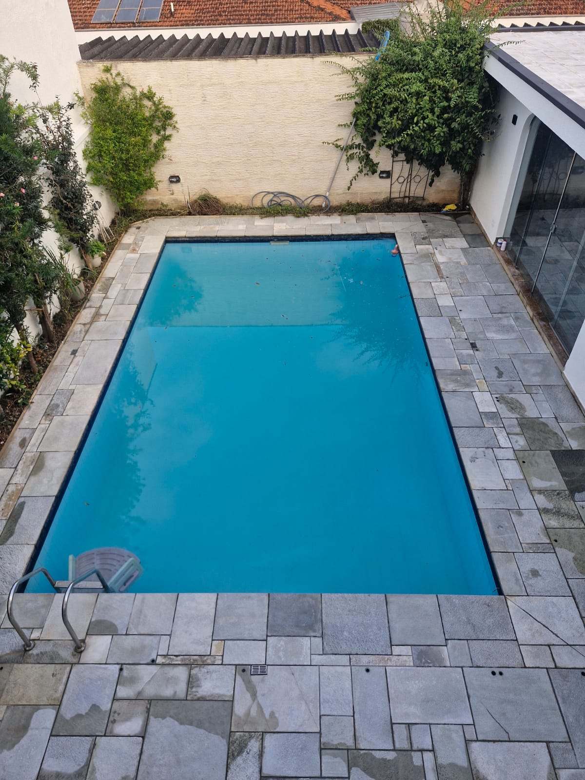 Área externa da piscina restaurada e limpa depois