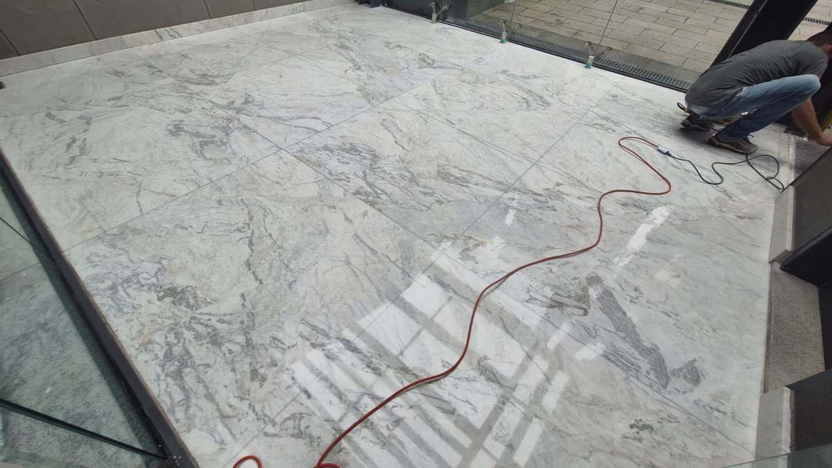 Polimento de mármore em andamento na entrada de empresa