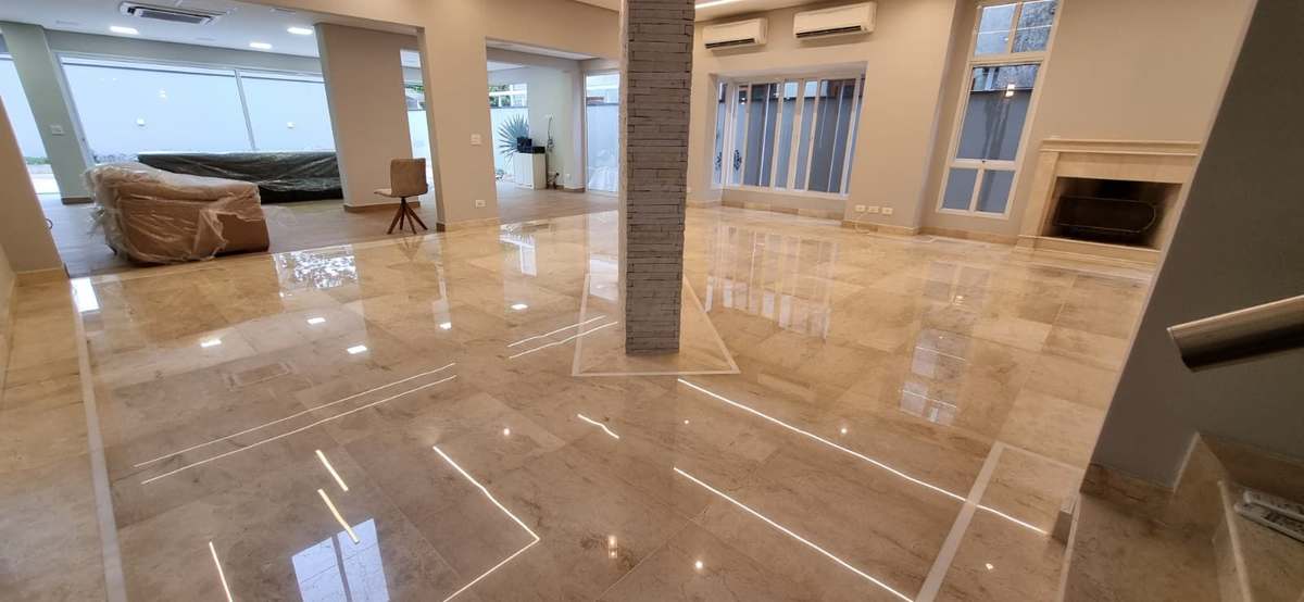 Amplo salão com mármore polido refletindo a iluminação do teto